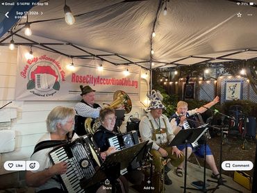 Band playing music at an outdoor event under string lights.