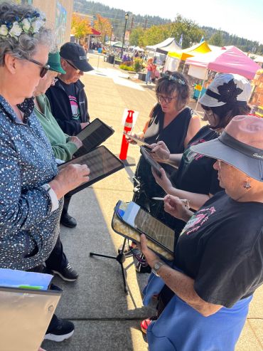 Group of people using tablets outdoors.