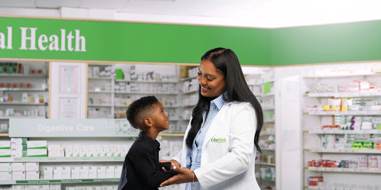 Pharmacist interacting kindly with a young boy in a pharmacy.