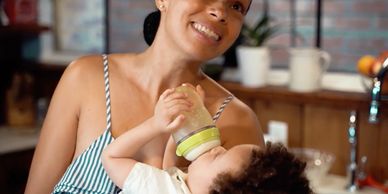Mother feeding baby with bottle.