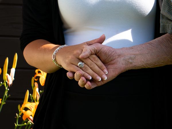 Trust in us caregiver holding hands with a patient outside.