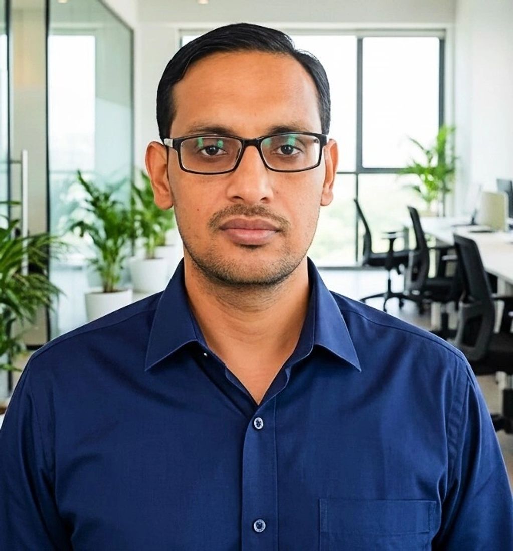 Professional man with glasses in a modern office setting.