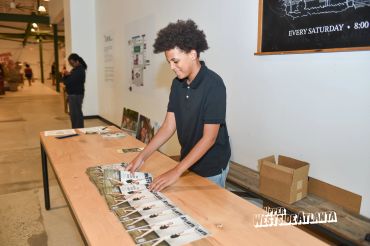 Teen arranging magazines on a table.