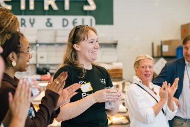 Group clapping and smiling indoors.