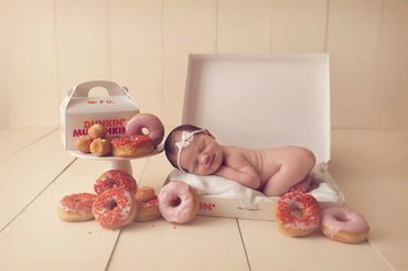Newborn Portrait of baby in Dunkin Donut Box and is smiling.