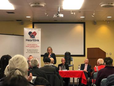 Panel discussion on heart health with Heartlink banner and attentive audience.