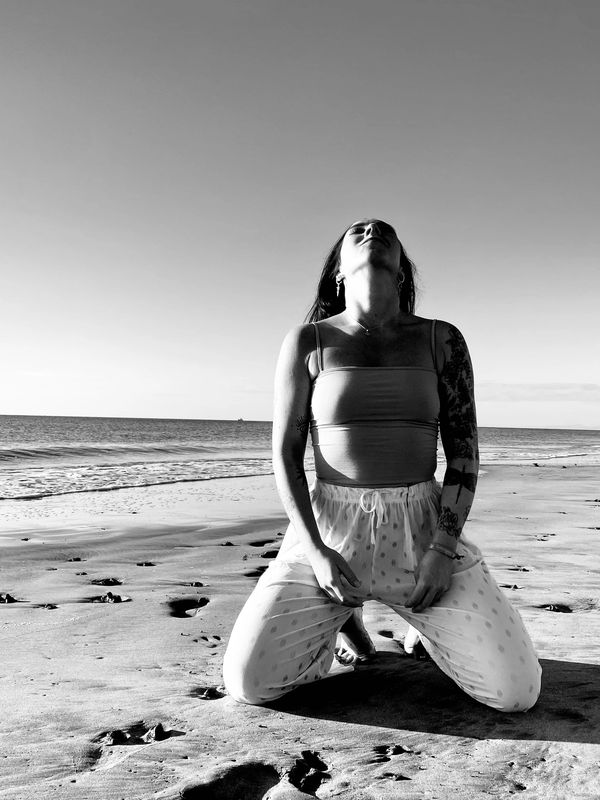 Marta Hyder sitting on her knees on a beach