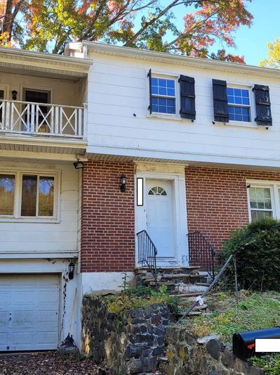 Two-story house with brick and white siding exterior.