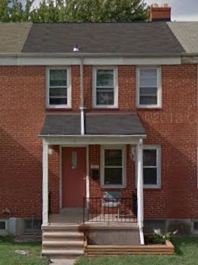 Brick two-story townhouse with a small front porch and steps.