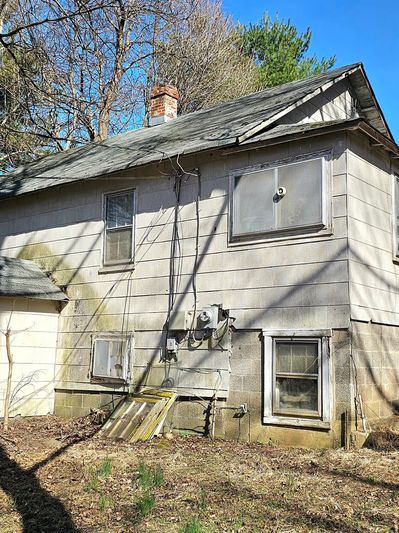 Old, weathered house exterior with peeling paint and moss.