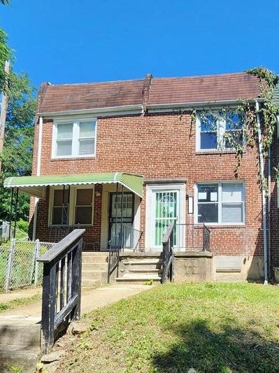 Brick two-story house with green door.