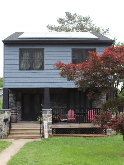 Two-story house with solar panels and a welcoming porch.