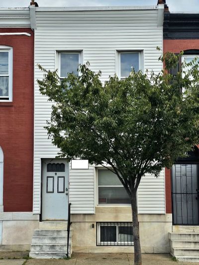 Two-story white house with tree in front.