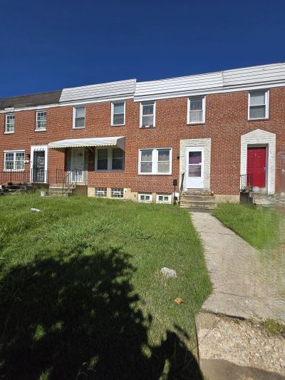 Row of brick townhouses under a clear blue sky.