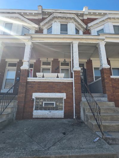 Old brick row house with white trim and stairs.