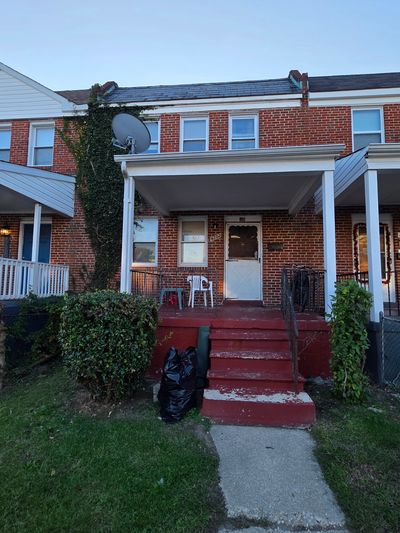 Red brick townhouse with red steps and satellite dish.