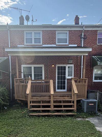 Backyard with wooden deck on a brick house.