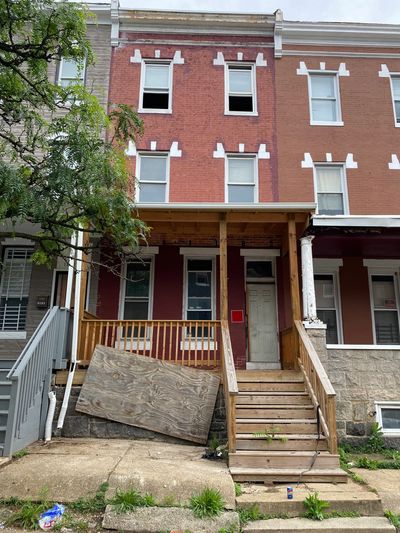 Wooden porch under construction on a brick building with stone foundation.
