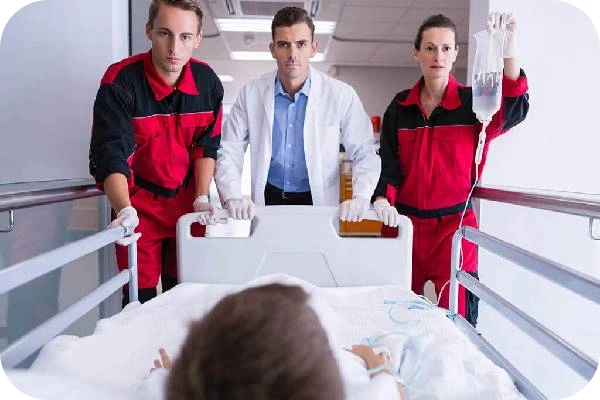 Three medical staff in red uniforms attend a patient, highlighting trauma care services.