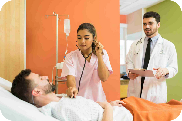 Doctor monitors a patient’s heart rate during an in-patient checkup in a hospital room.