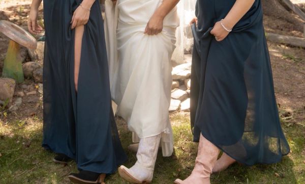 Three women wearing dresses and boots.