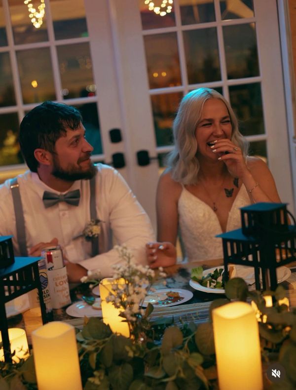 A couple shares a joyful moment at a candlelit dinner.