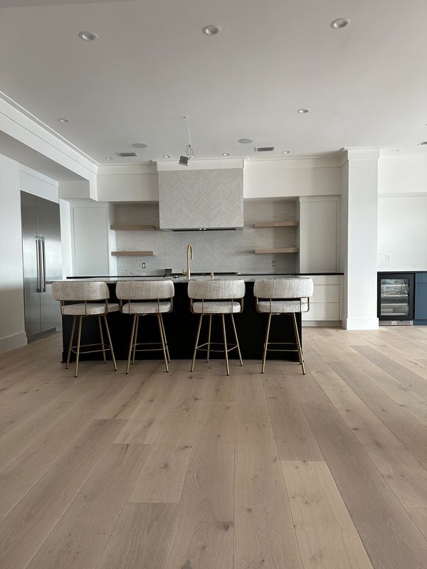 Modern kitchen with an island and four upholstered bar stools.