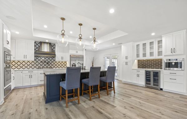 Modern kitchen with white cabinets and dark island.
