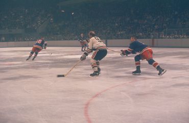 Bobby Hull retrieves the loose puck and is now off to the races. 