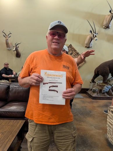 Man holding a Browning firearm brochure indoors.