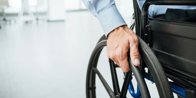 Close-up of a person in a wheelchair, representing disability management services.