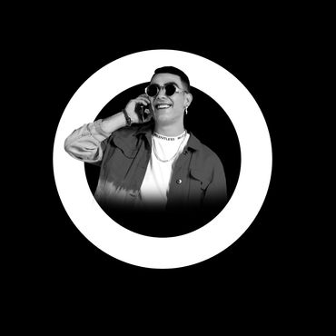 Person smiling and talking on phone inside a white circular frame on black background.