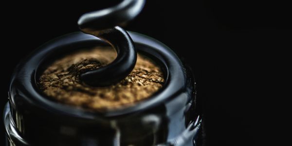 Close-up image of corkscrew opening a bottle of wine