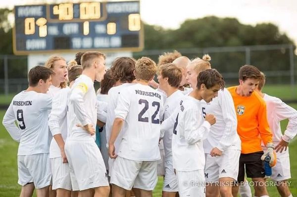 High school soccer team huddling before game.
