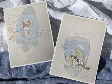 Two whimsical drawings of cats in space-themed settings with handwritten notes.