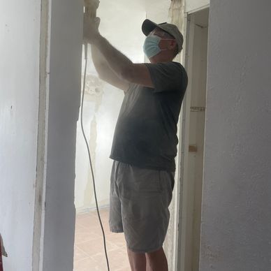 Bill detail sands the door frame in preparation to install the door