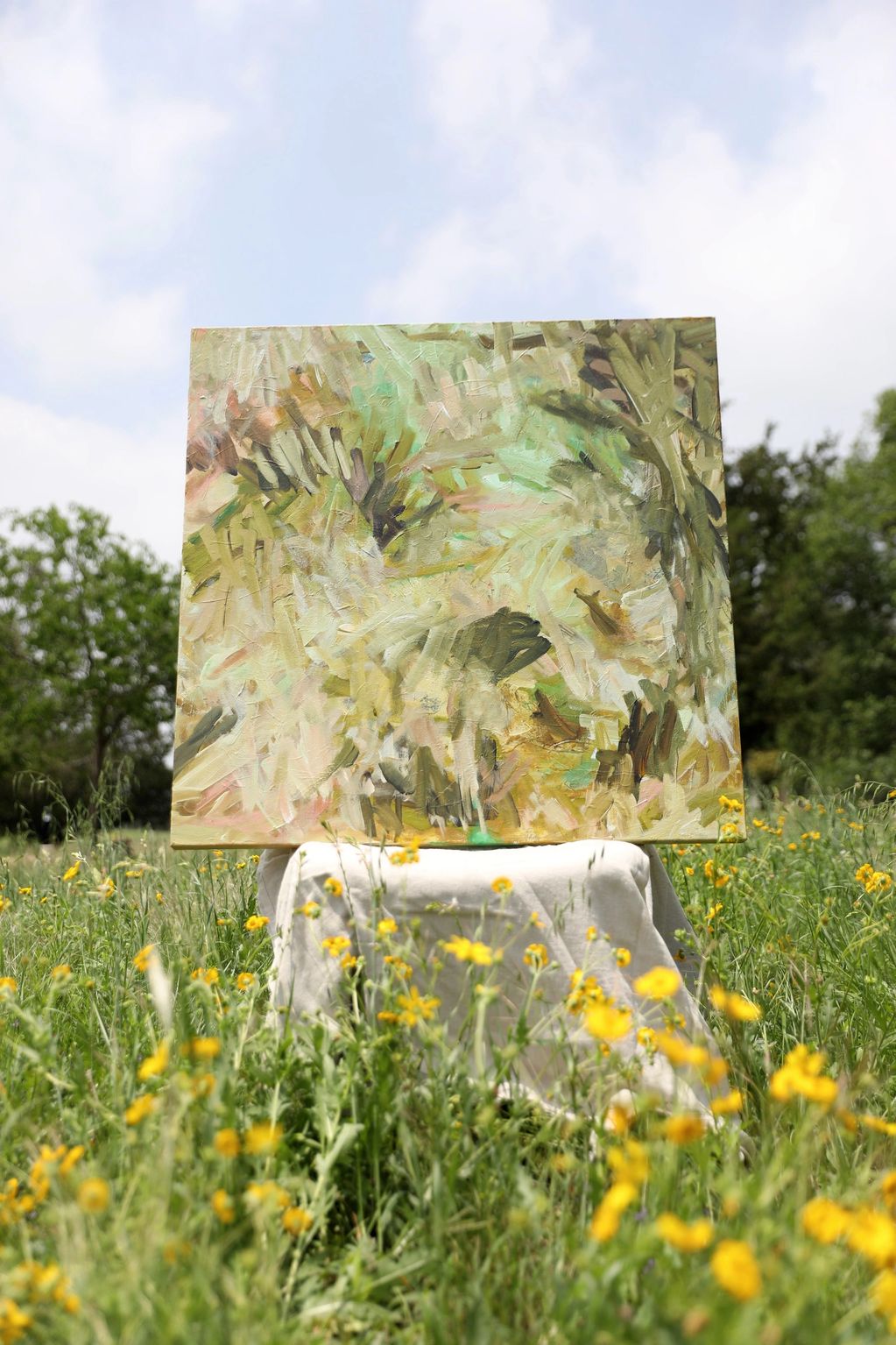 Abstract painting on a chair in a sunny flower field.