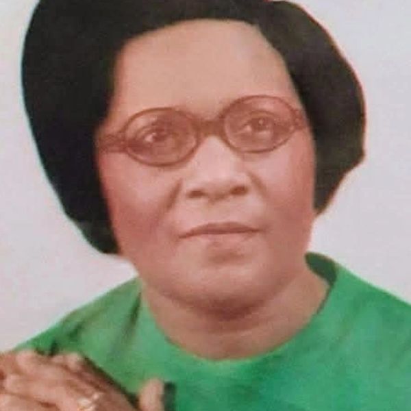 Portrait of a woman in glasses and green attire.