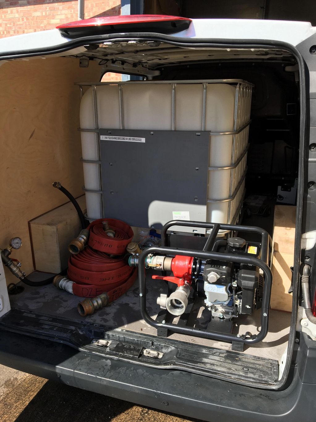 Water pump setup with hoses in a van.