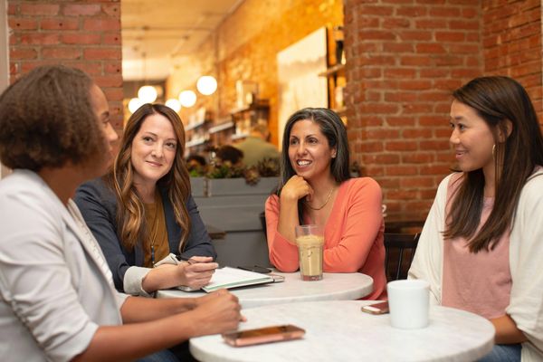 a group of women at a table discussing 