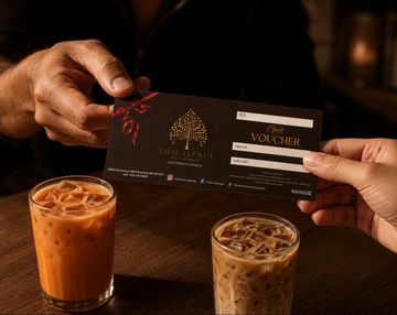 Two hands exchanging a gift voucher with iced drinks on a table.