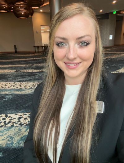 Smiling woman with long blonde hair in professional attire.