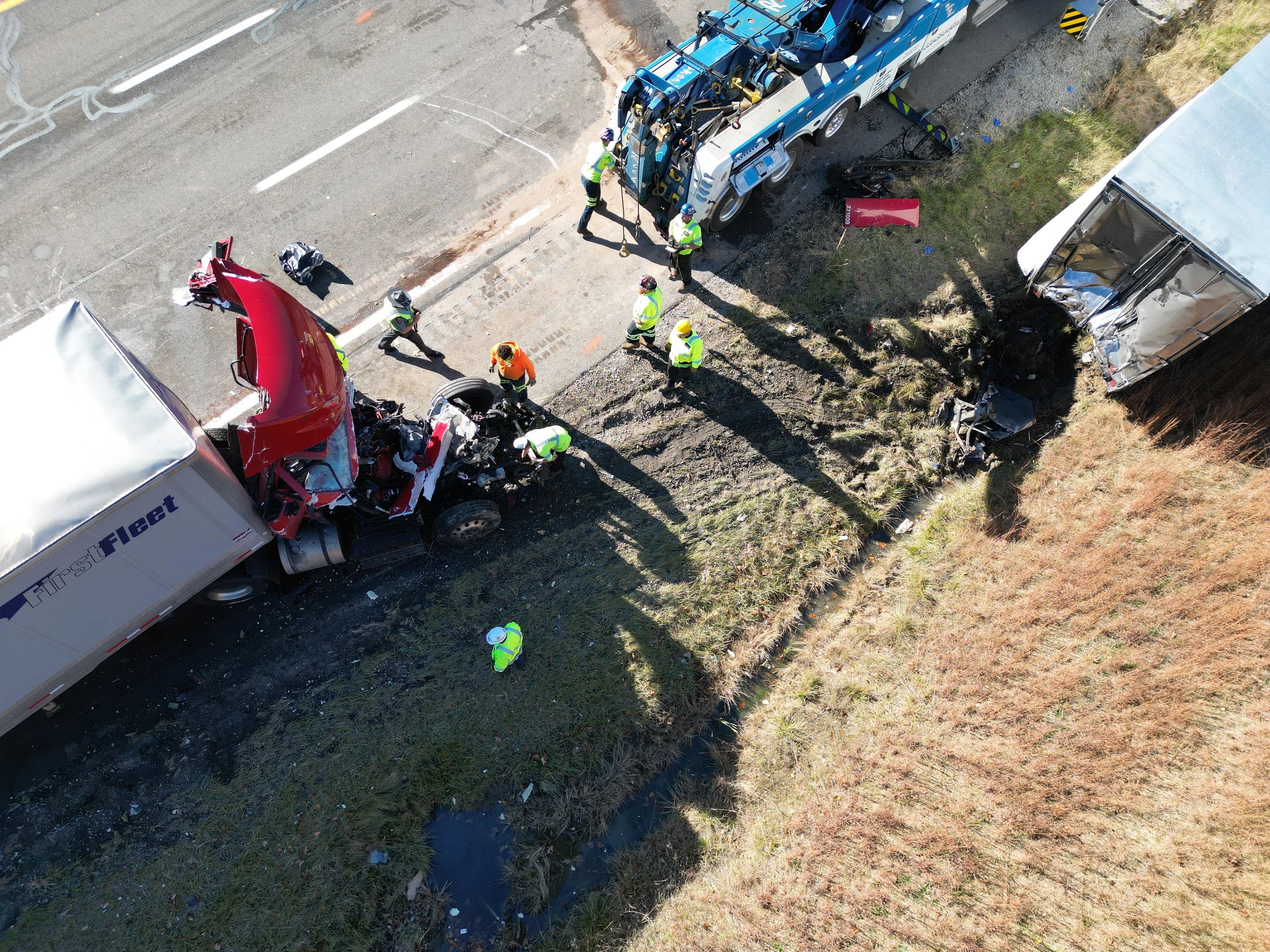 Semi truck with heavy damage after crashing into the rear trailer of another semi.