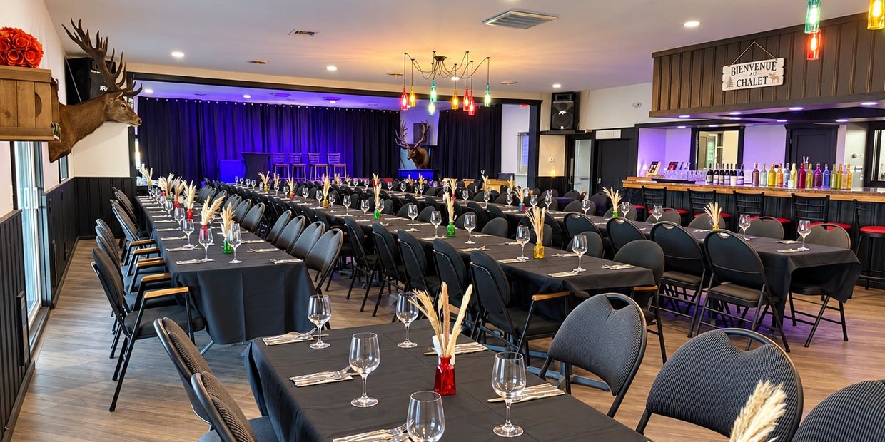 Salle avec tables et chaises dressées pour un événement.