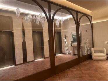 Elegant lobby with glass doors, modern sculptures, and comfortable seating.