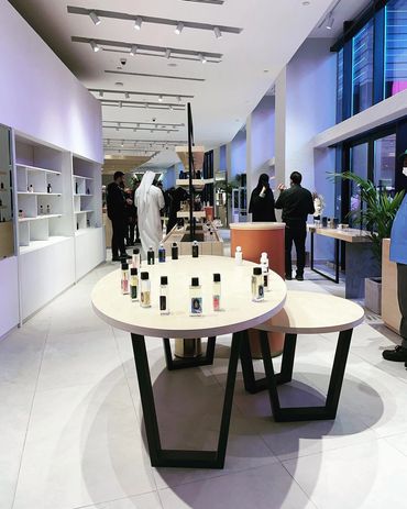 Modern perfume store with minimalist design and customers browsing products.