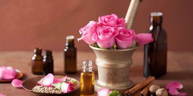 rose essential oil and roses in a vase