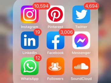 an iPhone with social media icons for Facebook, Instagram, Twitter and more with many notifications