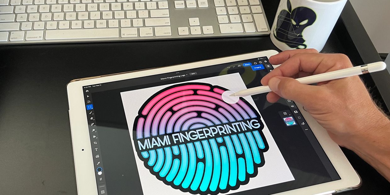 a designer from Miami Beach Marketing 305 using an iPad to design the logo for Miami Fingerprinting