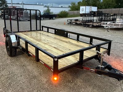 Utility trailer with wooden base and metal frame on gravel.